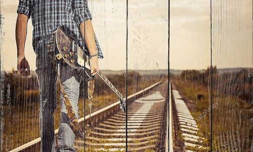 Человек с гитарой на железной дороге