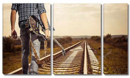 Человек с гитарой на железной дороге