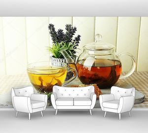 Стеклянные чашка и чайник с чаем