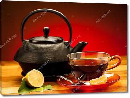Чашка черного чая с чайником  и лимоном