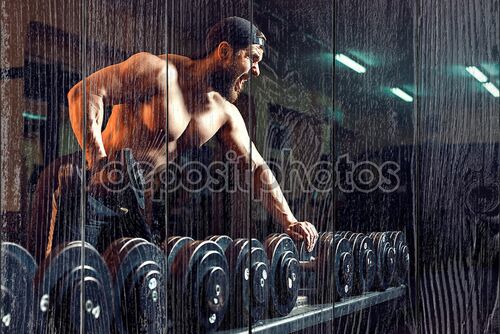 Мускулистые мужчины культурист, тренируясь в тренажерном зале