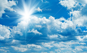 Синее небо с солнцем в облаках