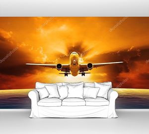 пассажирский реактивный самолет, пролетающий над красивым уровнем моря с закатом