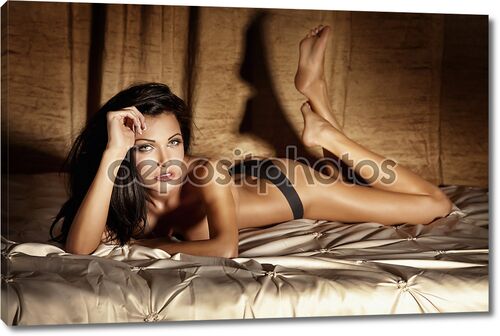 Молодая сексуальная женщина в нижнем белье, лежа в постели, расслабляющий