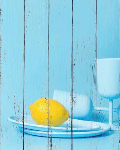 Лимон на голубой тарелке с бокалами