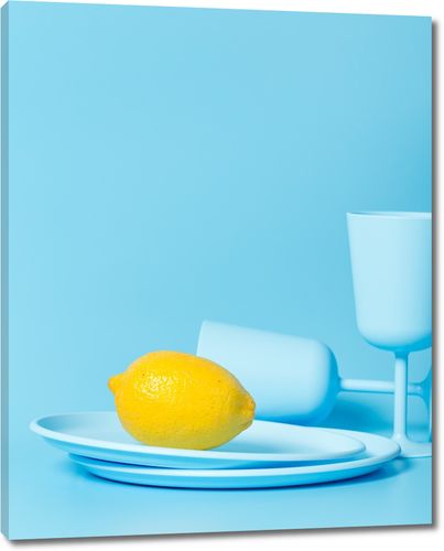 Лимон на голубой тарелке с бокалами